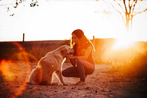 woman squatting near her dog